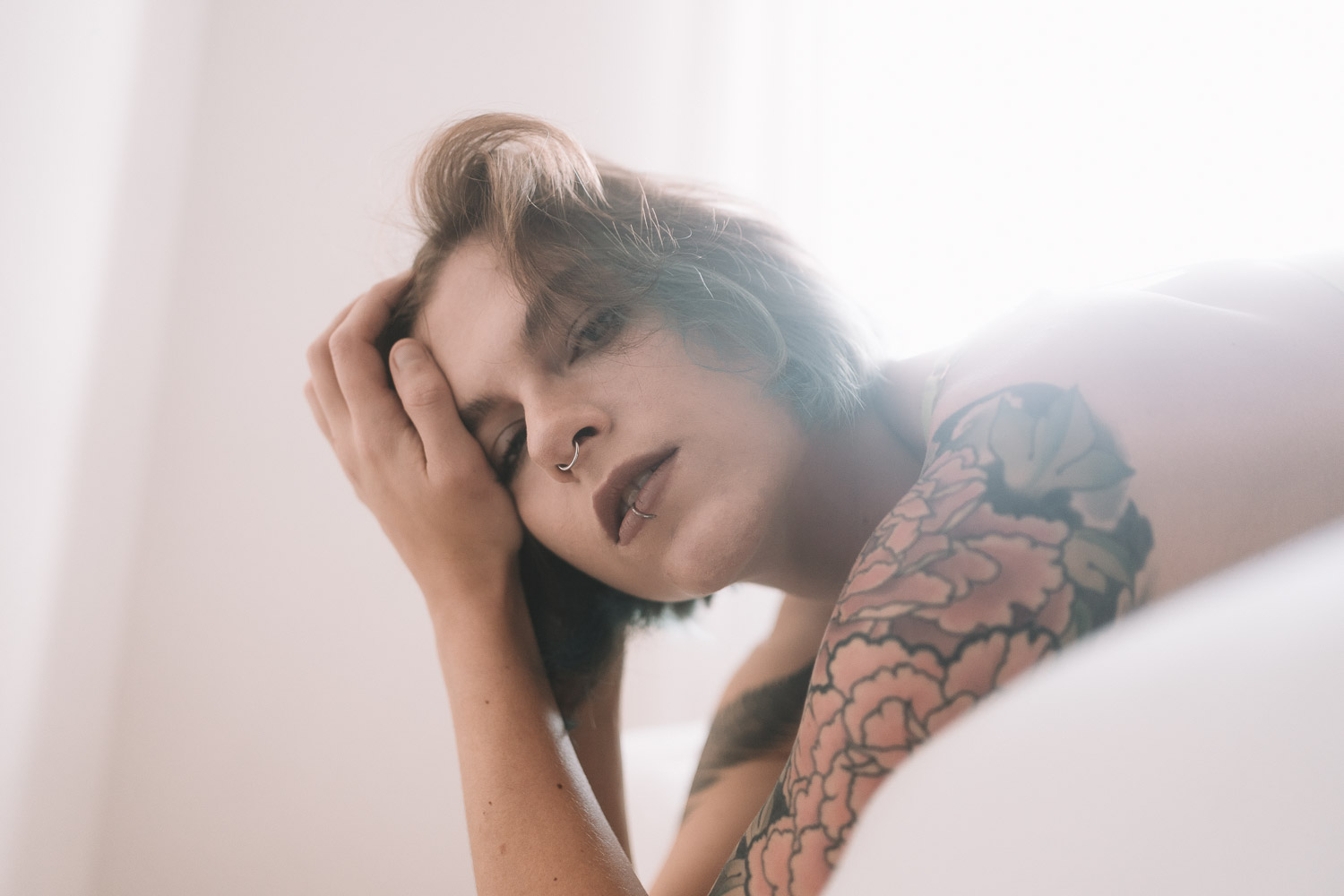 Woman with short blonde hair touching her head in soft focused portrait