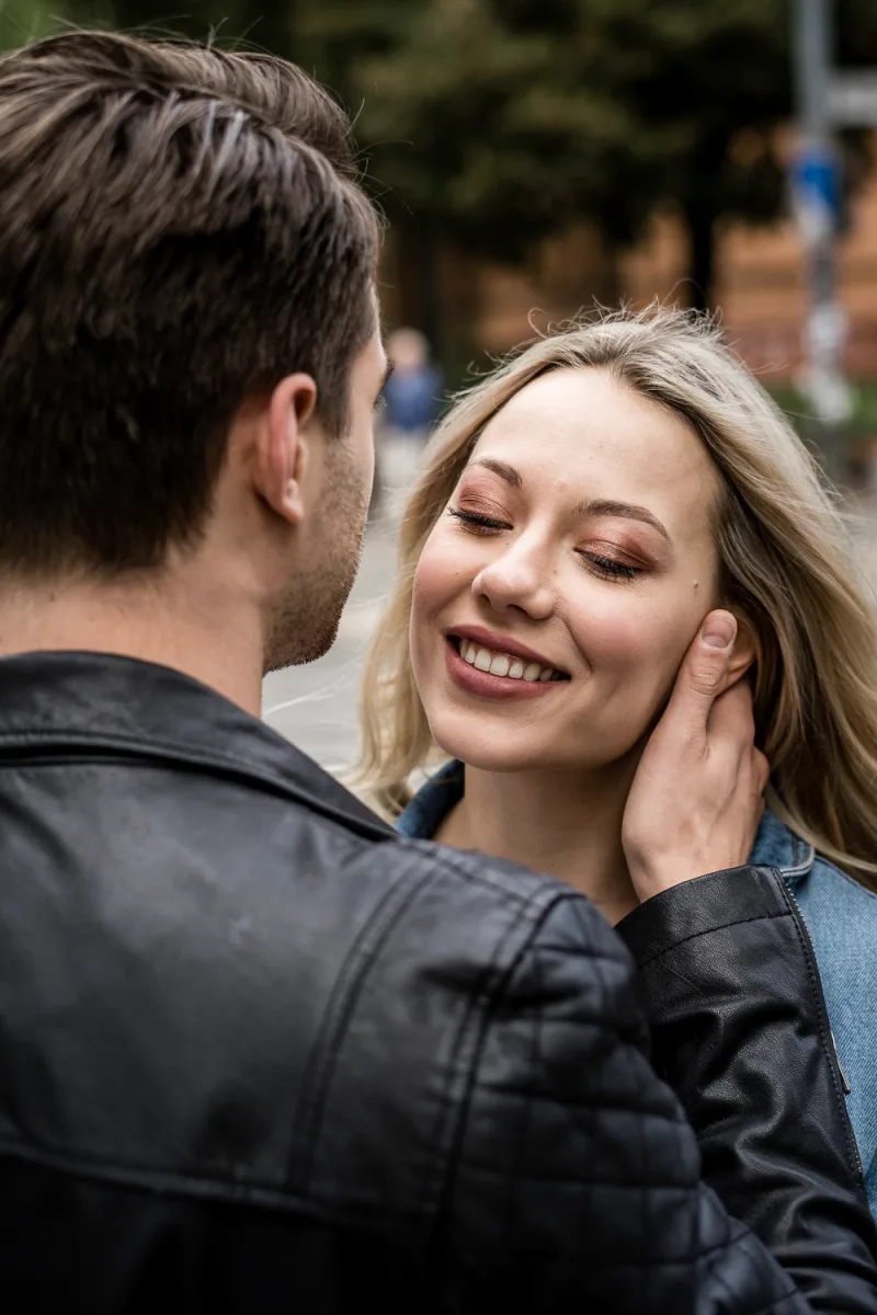 Man and woman smiling together outdoors with man in dark jacket
