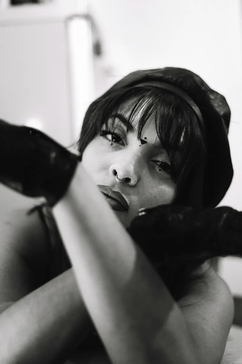Woman with short dark bangs and black hat in profile black and white portrait