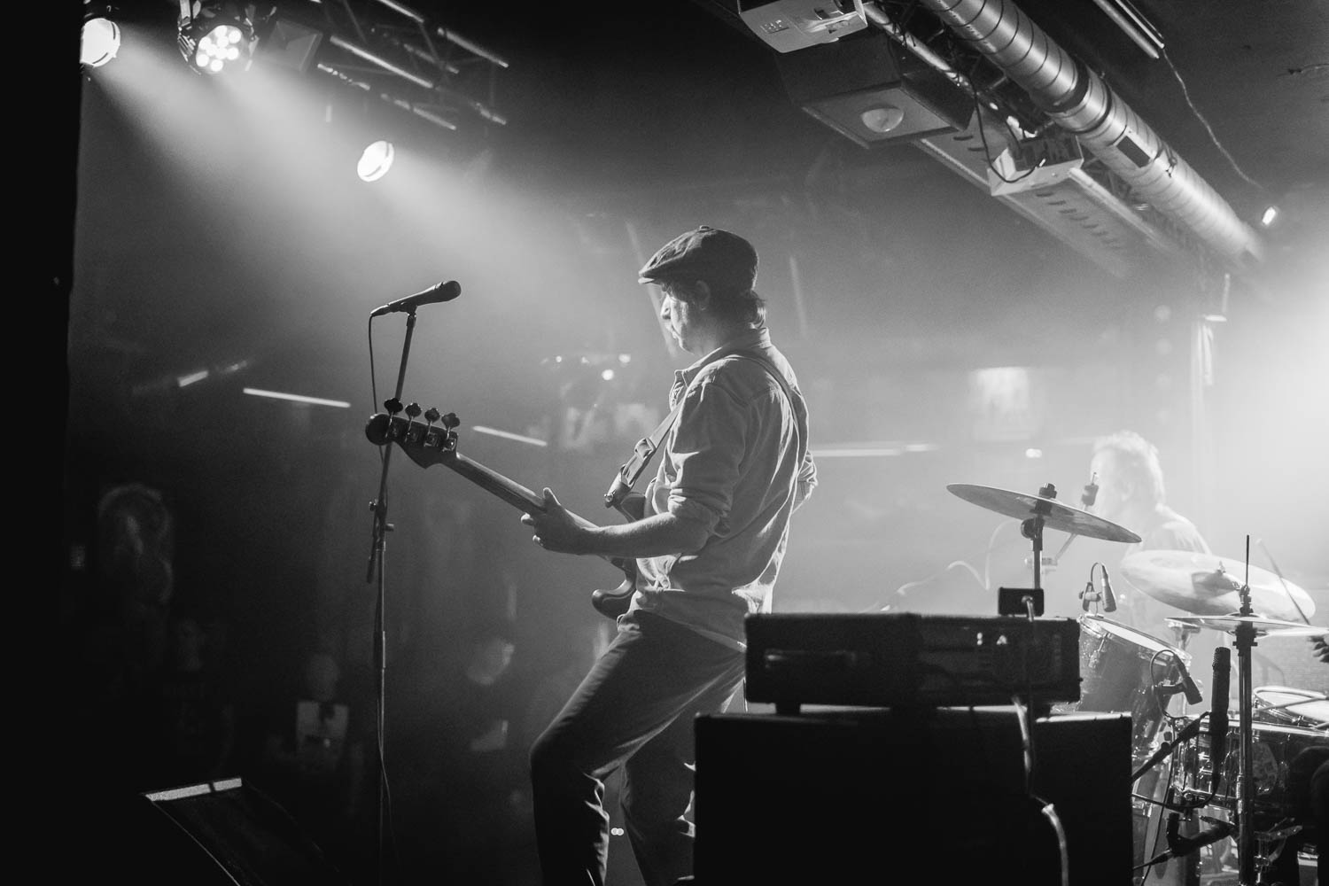 Musician playing electric guitar on concert stage with dramatic stage lighting