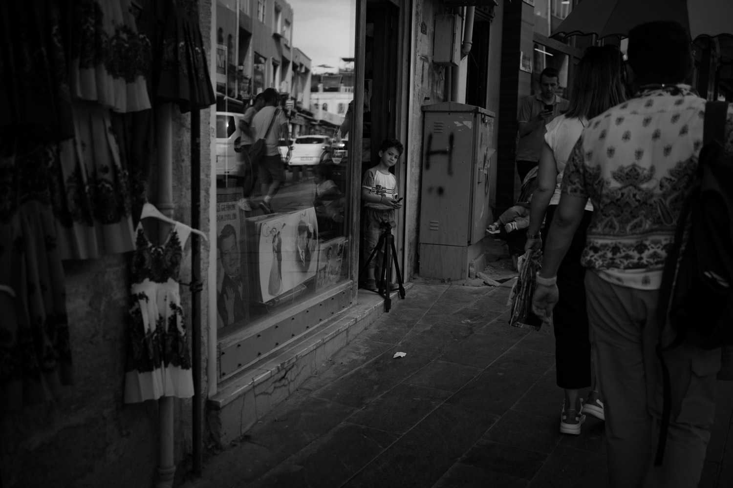 Woman on narrow European street looking over shoulder, bicycle visible in background